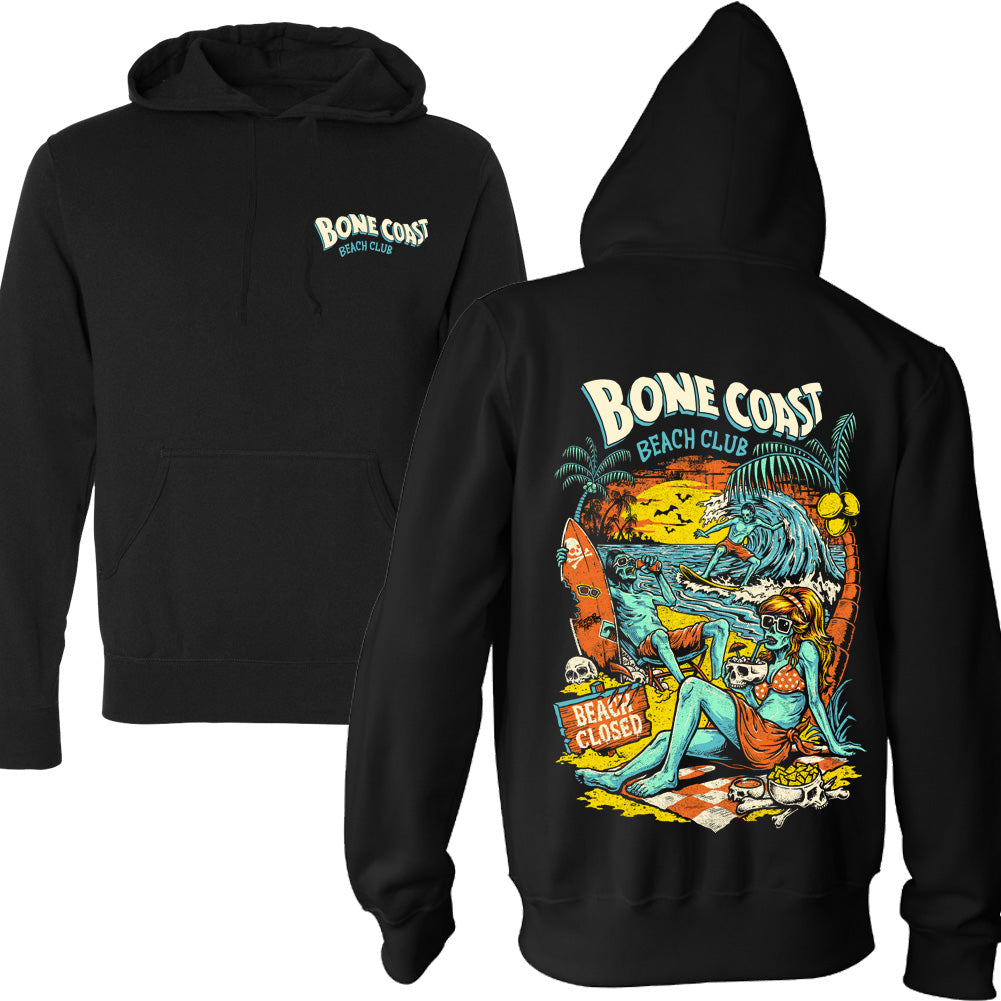 Bone Coast Beach Club black pullover hoodie featuring a small front chest logo and large back print with skeleton beachgoers, a surfer, palm trees, skulls, waves, and a beach closed sign in a retro tropical horror design.