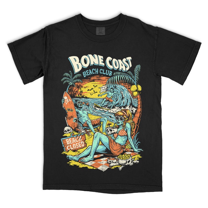 Bone Coast Beach Club black Comfort Colors t-shirt featuring skeleton beachgoers, a surfer, palm trees, skulls, waves, and a beach closed sign in a retro tropical horror design.