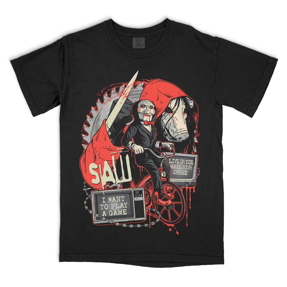 Black Comfort Colors SAW Make Your Choice T-Shirt featuring Billy the Puppet on his tricycle, the pig mask, circular saw blade, knife and blood-red film imagery.