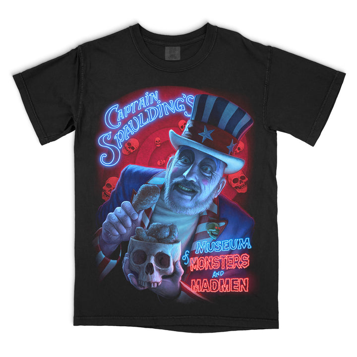 House Of 1000 Corpses “Monsters and Madmen” T-Shirt showcasing Captain Spaulding with glowing neon-style text and skull imagery, printed on a black Comfort Colors relaxed fit tee.