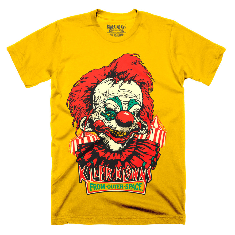 Officially licensed Killer Klowns From Outer Space Step Right Up yellow t-shirt featuring a sinister red-haired Killer Klown with a toothy grin, striped circus tents, and the iconic movie logo.