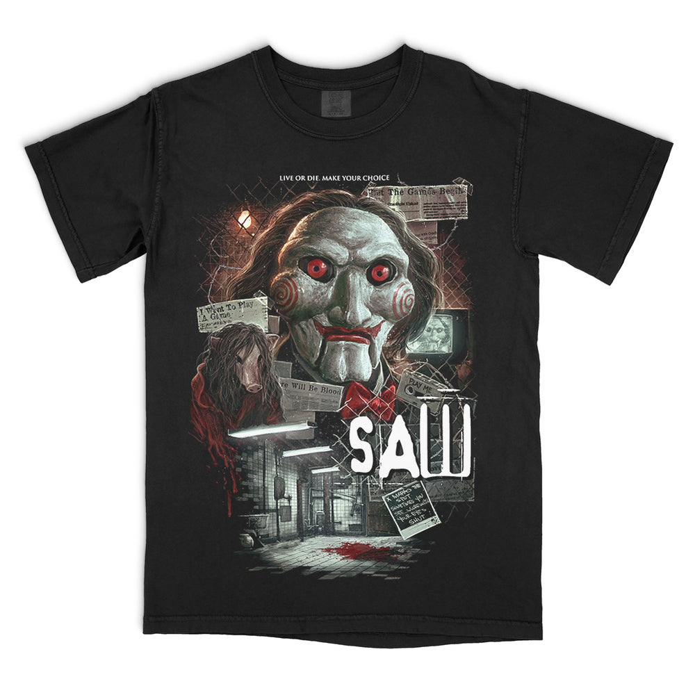 Black Comfort Colors SAW Want To Play A Game T-Shirt featuring Billy the Puppet, Amanda Young, the bathroom trap and distressed film imagery.